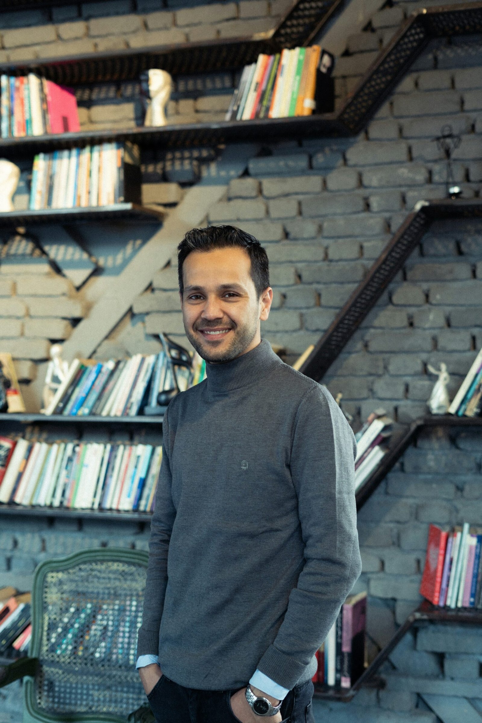 a man standing in front of a bookshelf