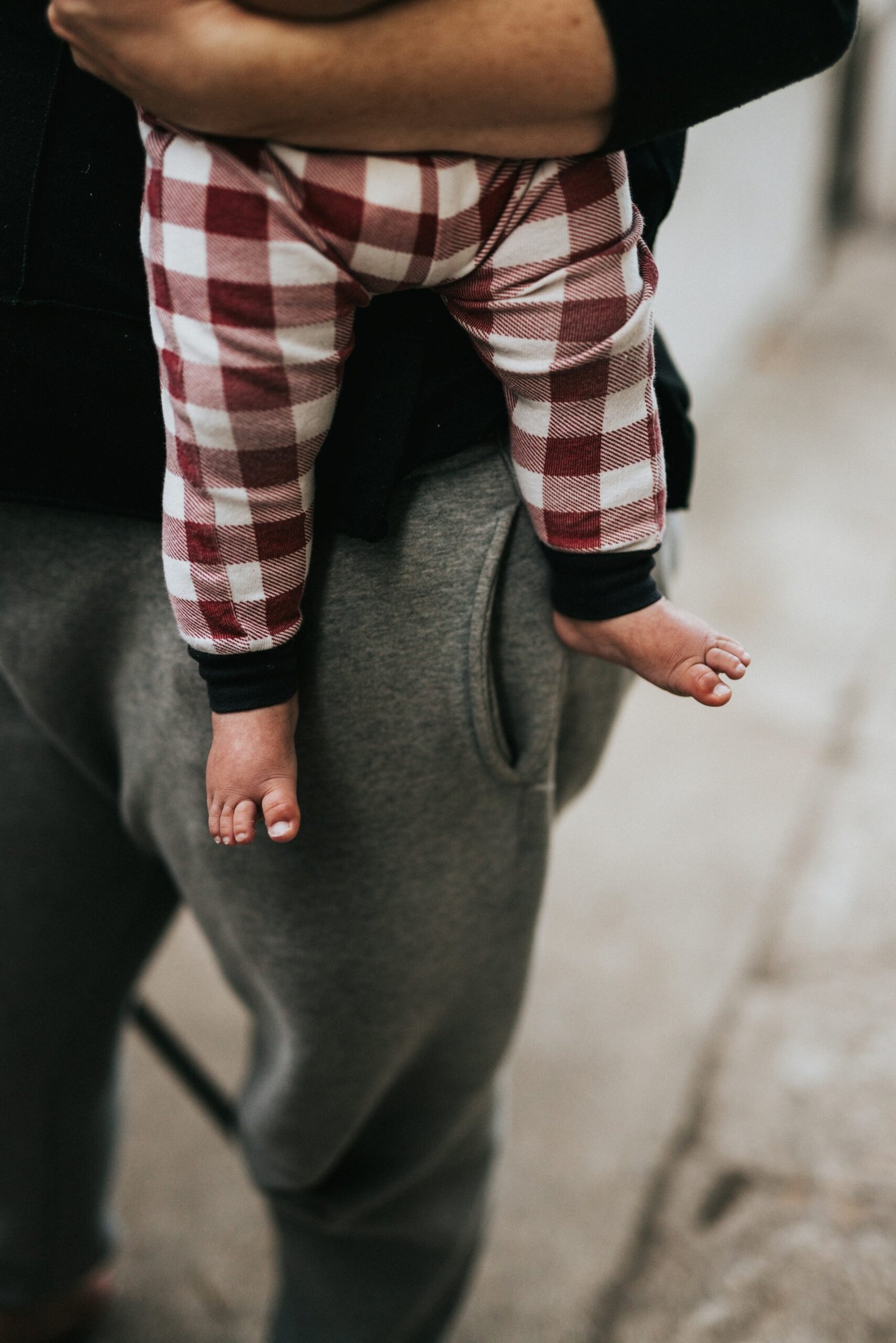 person in red white and black plaid long sleeve shirt and gray pants sitting on black